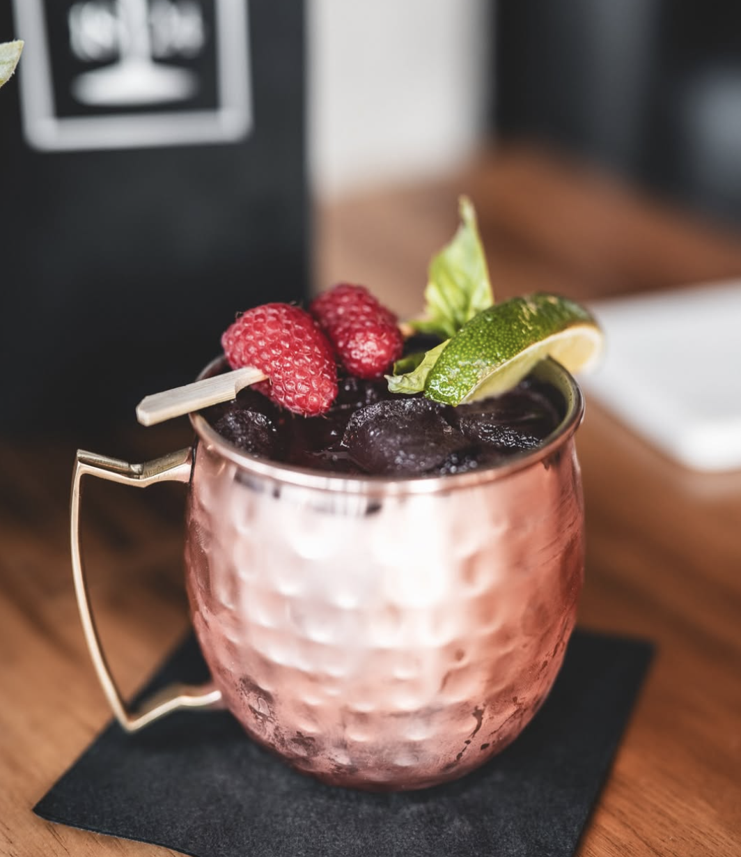 Berry Moscow Mule in a hammered copper mug with raspberries and lime